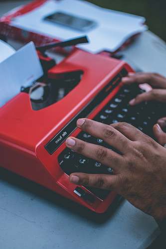 english study person typing on red typewriter writer